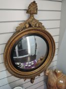 A large early 20th century circular convex mirror having gilt plaster frame and ornate detailing,