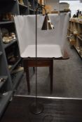 A modern bronzed metal standard lamp with adjustable conical shade