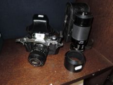 A photographic camera the Canon AE-1 and a Tamron 1:3.8 lens