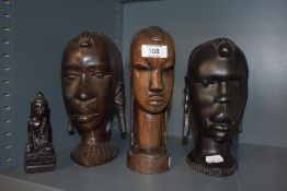 A small Oriental carved wood deity together with three carved African hardwood busts.