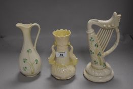 Three pieces of Belleek porcelain, sea serpent handled vase, harp ornament (green backstamps) and