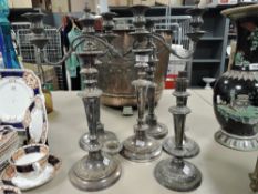 Three sets of silver plated candle sticks including three branch with scrolling arms