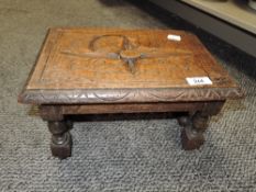 An early 20th century oak stool, of small proportions, carved and incised seat over barley-twist