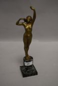 An early 20th century bronze figurine depicting nude lady stretching on green marble base, incised