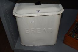A vintage white enamelled metal bread bin, with cover, some enamel losses, cover lacking handle.