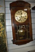 An early 20th Century oak cased wall clock having roman numeral dial