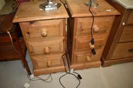 A pair of modern pine narrow bedside cabinets