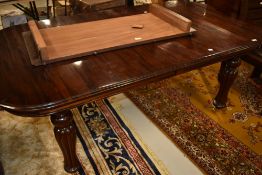 A reproduction mahogany extending dining table, in the 19th century style with fluted legs and brass