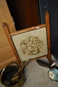 An Arts and Crafts style golden oak fire screen having embroidered panel