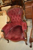A Victorian button back armchair having dralon uphostery on scroll frame