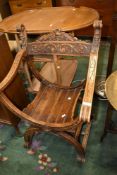 A Savonarola style chair of traditional form with scroll frame