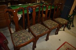 A set of four early 20th Century mahogany dining chairs having vase backs, drop in seats and