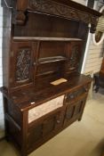 A period oak dresser having court cupboard style back section, naively carved decoration and