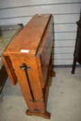 An Arts and Crafts golden oak drop leaf standing table having twist top, in the Arthur Simpson
