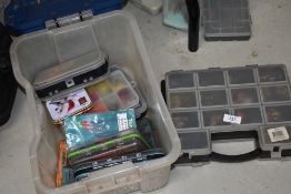 A large selection of Large salmon fishing Flies in various containers