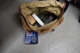 A canvas fishing bag and contents including fly and spinning reels.