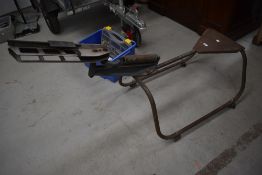 A vintage manual clay pigeon trap with metal frame and seat