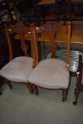 A pair of early 20th Century mahogany lounge chairs having carved back , upholstered seats and