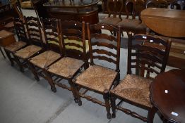 A harlequin set of six rush seated ladder back chairs