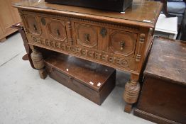 A traditional oak side table in the Jacobean style having two deep frieze drawers