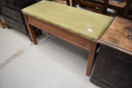 A traditional golden oak duet piano stool