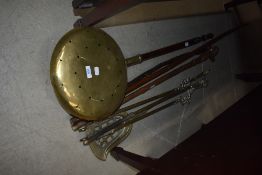 A selection of brass fire irons, chestnut roaster etc