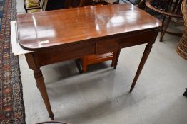 A 19th Century mahogany fold over tea table having inlay decoration to frieze, on turned legs