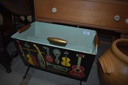A vintage tin plate magazine or sheet music stand with musical themed decoration
