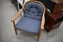 A vintage armchair, in the Ercol style, very stylised design