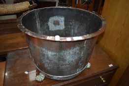 A large copper coal or log basket with brass feet