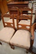 A set of four Victorian mahogany dining chairs having carved backs, overstuffed seats and turned