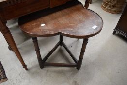 An early 20th Century oak occasional table have clover style top, three legged frame