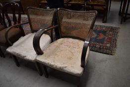 A pair of stained frame bergere backed armchairs