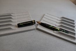 A Conway Stewart Dandy leverfill fountain pen in green and black marble with two narrow bands to cap
