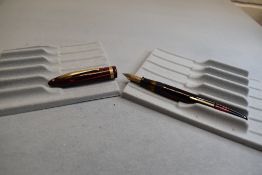 A SheafferBalance Lifetime leverfill fountain pen in red striated with single band to cap having