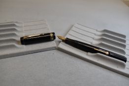 A leverfill fountain pen in black (name rubbed and indistinct) bearing a B to clip with two narrow