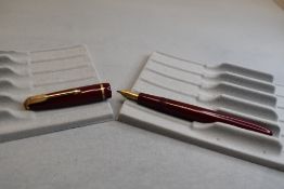 A Parker Slimfold fountain pen in burgundy with narrow decorative band to the cap and having a