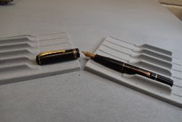 A Burnham 'The Burnham' leverfill fountain pen in black with three narrow bands to the cap having