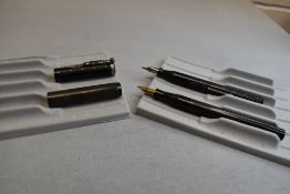 Two un-named leverfill fountain pens in HBR one discoloured and engraved