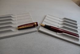 A Mabie Todd & Co Swan Leverless twist filler, in maroon with two narrow and one broad band to cap