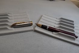 A Sheaffer Clipper TM Snorkel fill fountain pen in burgundy having silver cap with gold trim