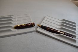 A Conway Stewart 12 leverfill fountain pen in red marble with single band to the cap having a Conway