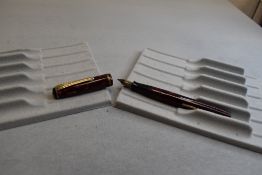 A Burnham No49 leverfill fountain pen in red marble with single narrow band to the cap having