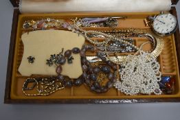 A jewellery box containing a selection of costume jewellery including stop watch, crystal beads,