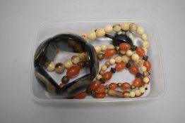 An animal horn and similar amber bead style necklace