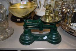 A modern pair of cast kitchen balance scales with brass style weight set