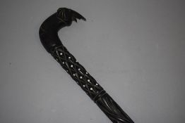 An antique ebony walking stick having carved shaft with elephant head handle