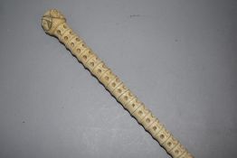 A late 19th century sharks spine walking stick or cane decorated with Japanese style face masks to