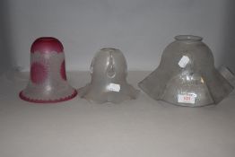 A group of three glass lamp shades