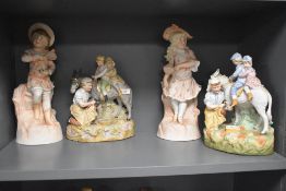 A group of four figurines including two variants of a farrier shoeing a donkey with two children